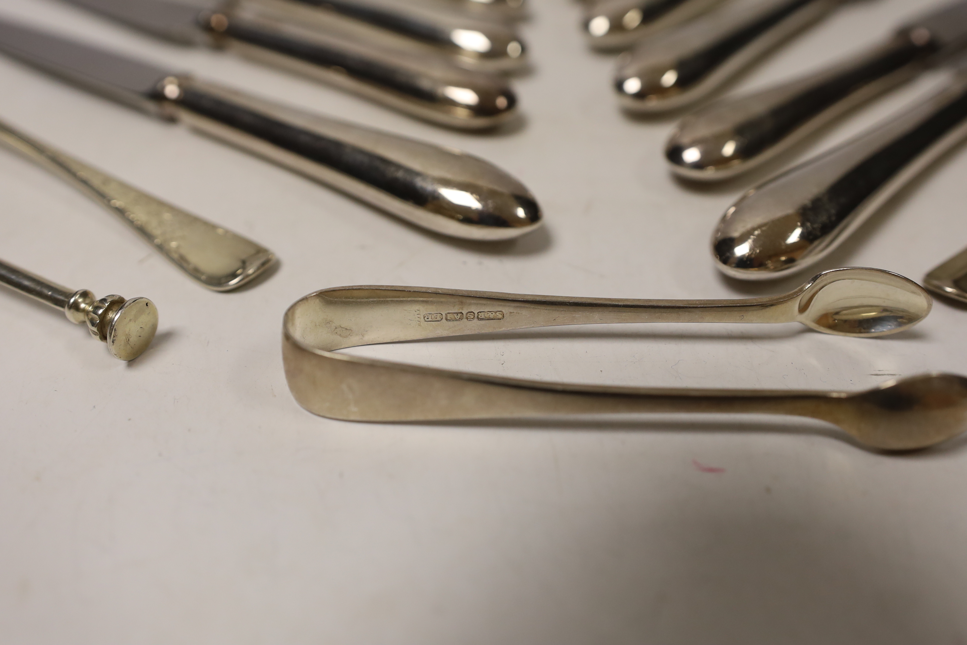 A set of six modern silver handled table knives and dessert knives, United Cutlers, Sheffield, 1997/8, a small silver five bar toast rack, two silver forks, a silver spoon and a pair of silver plated sugar tongs.